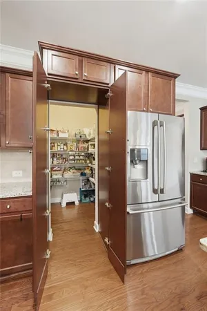 a kitchen with granite countertop a refrigerator and a stove top oven