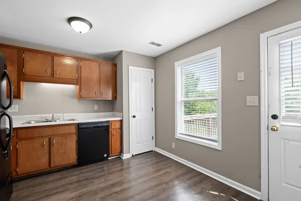 a kitchen with stainless steel appliances granite countertop a sink a stove cabinets and wooden floor