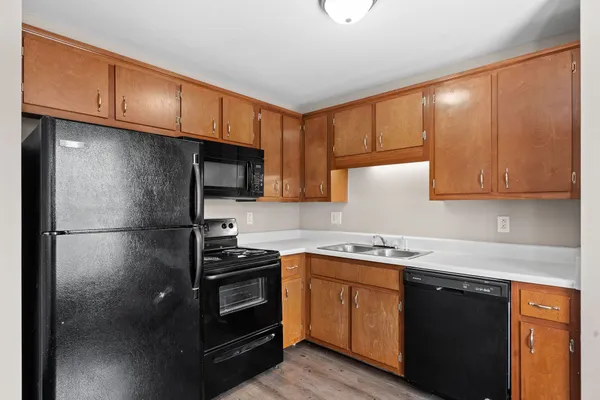 a kitchen with a sink a refrigerator and cabinets
