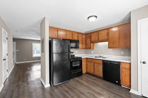 a kitchen with granite countertop stainless steel appliances a refrigerator a sink and cabinets