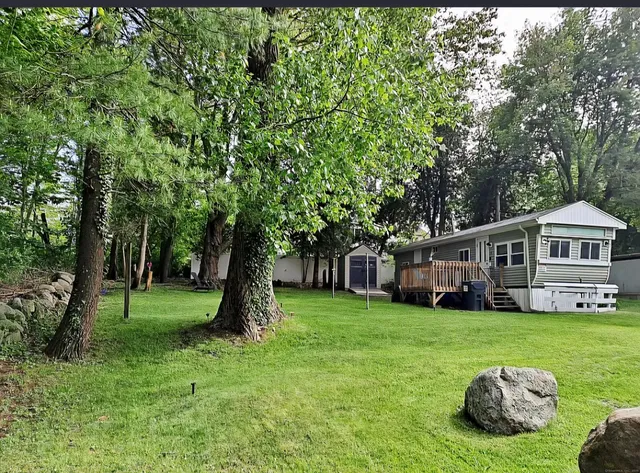 a view of a house with a yard and sitting area