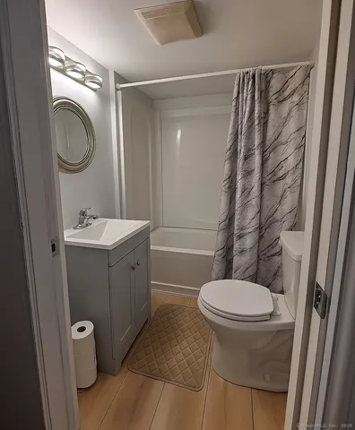 a bathroom with a toilet sink a mirror a vanity and shower