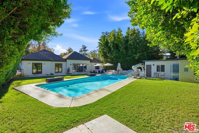 a aerial view of a house with swimming pool patio and yard