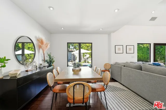 a dining room with furniture a rug and a large window