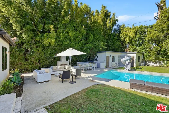 a view of a house with a yard and sitting area