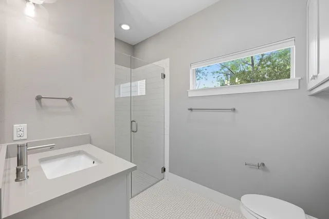 a bathroom with a sink toilet and window