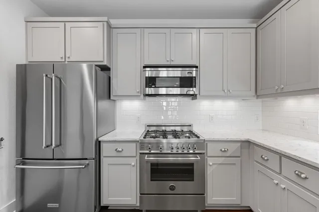 a kitchen with appliances a sink and a refrigerator
