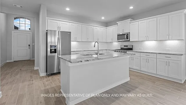 a kitchen with a refrigerator a sink and cabinets