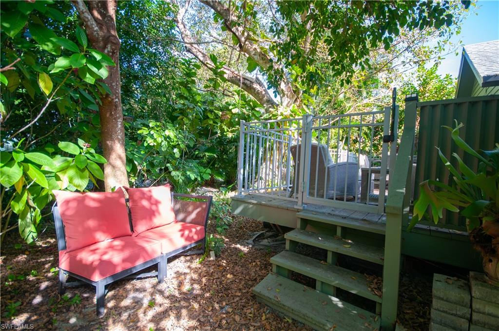 1313 Solana Road, Unit A3 Naples, FL 34103 - Photo 28 of 29 View of back yard with a deck, steps to lush trees and paths