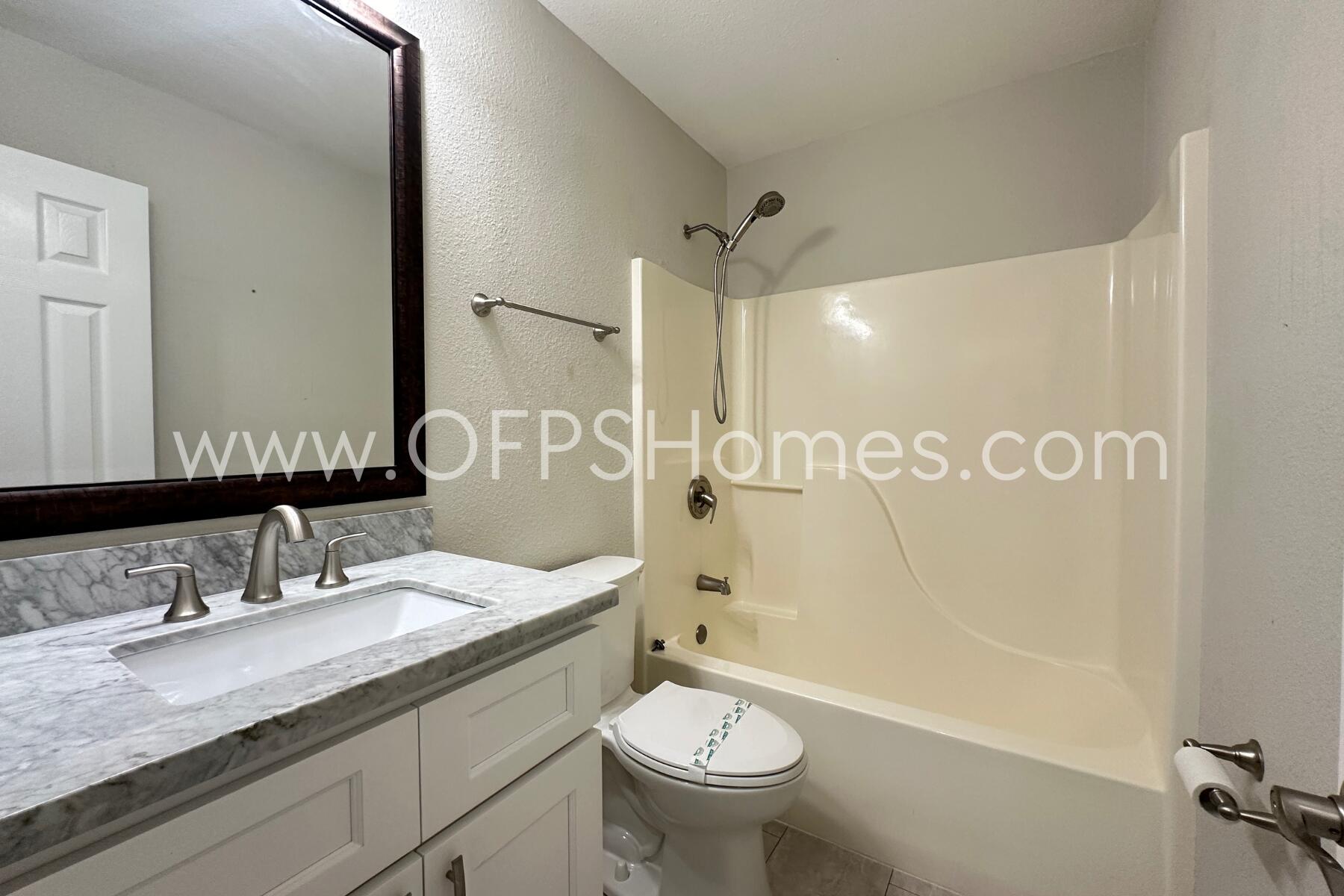 932 Emily Circle Fort Walton Beach, FL 32547 - Photo 11 of 20 a bathroom with a granite countertop sink toilet and shower