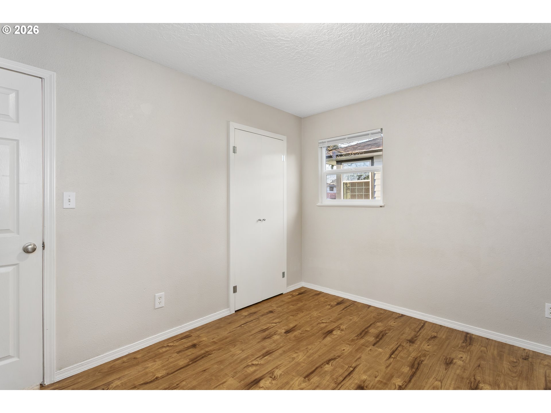 8705 Southeast Pardee Street Portland, OR 97266 - Photo 21 of 32 an empty room with wooden floor and windows