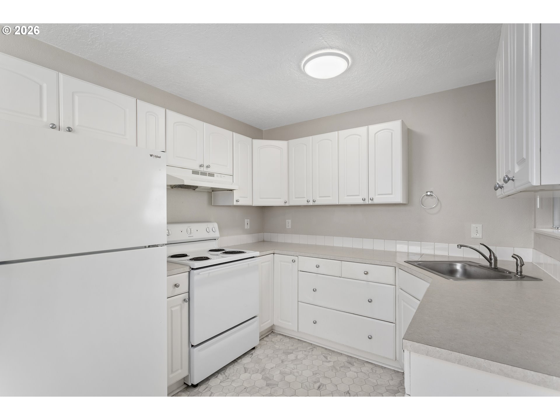 8705 Southeast Pardee Street Portland, OR 97266 - Photo 6 of 32 a kitchen with white cabinets and white appliances
