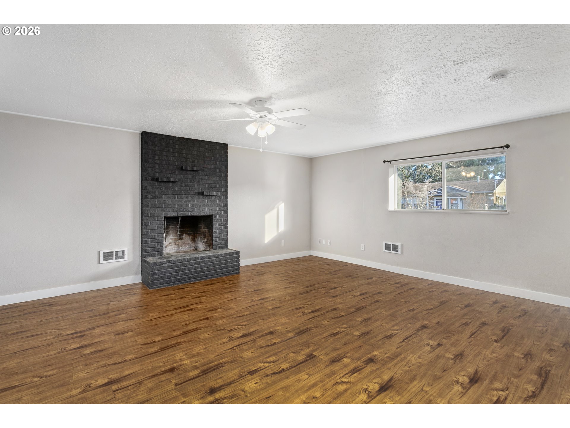 8705 Southeast Pardee Street Portland, OR 97266 - Photo 10 of 32 a view of empty room with wooden floor and fan