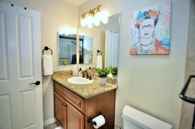 a bathroom with a granite countertop sink and a mirror