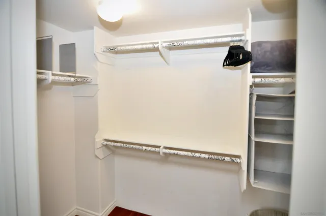 a view of walk in closet with empty racks