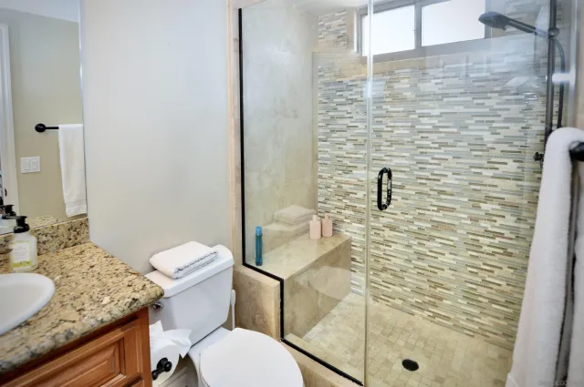 a bathroom with a granite countertop toilet sink and shower