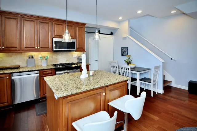 a kitchen with a table chairs microwave and cabinets