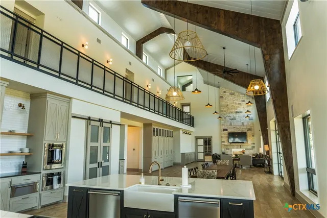 a living room with furniture kitchen view and a large window