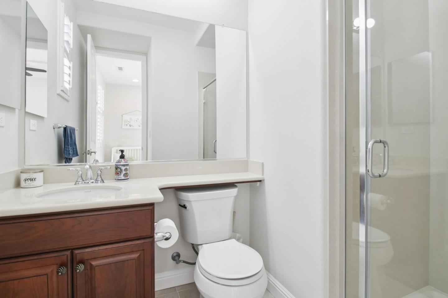 7670 MacKenzie Way Gilroy, CA 95020 - Photo 43 of 70 a bathroom with a toilet a sink a mirror and vanity