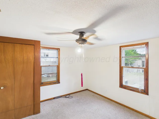 an empty room with windows and closet