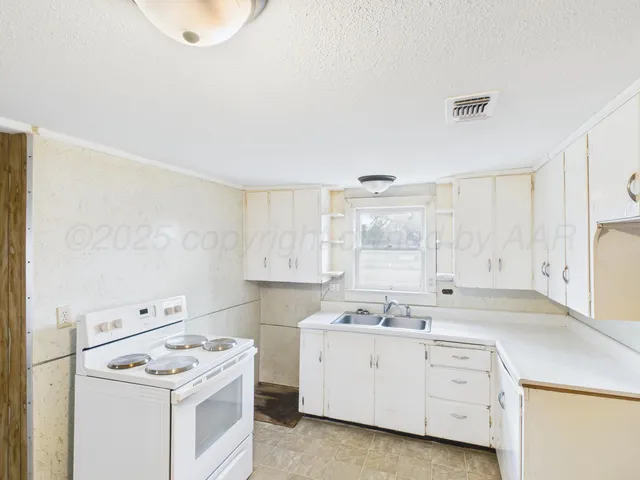 a room with a stove a sink and a window