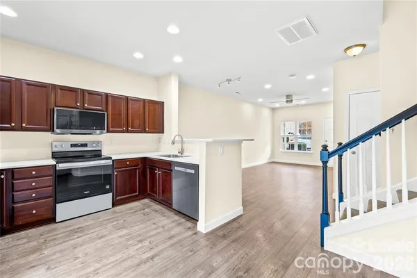 a kitchen with stainless steel appliances kitchen island granite countertop a stove a sink and a refrigerator