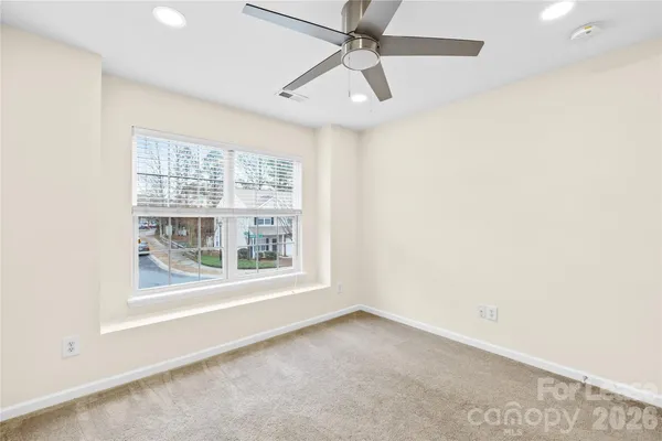 an empty room with a window and a ceiling fan