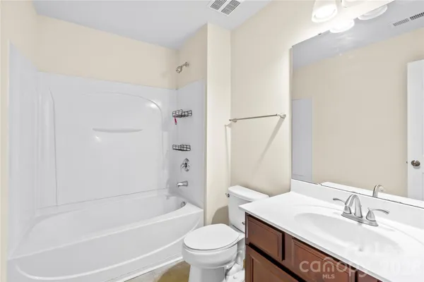 a bathroom with a sink a toilet and a large mirror