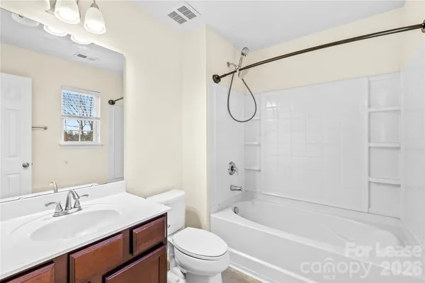 a bathroom with a sink a toilet a mirror and shower