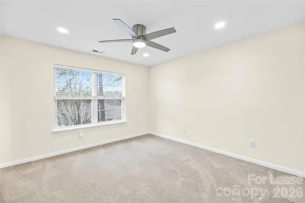 an empty room with windows and fan