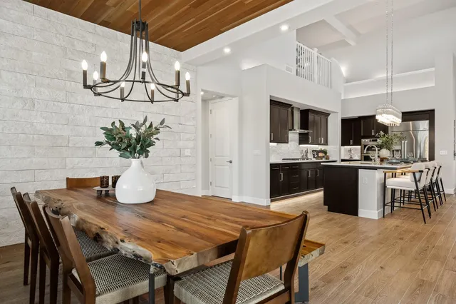 a dining room with stainless steel appliances kitchen island a table and chairs in it