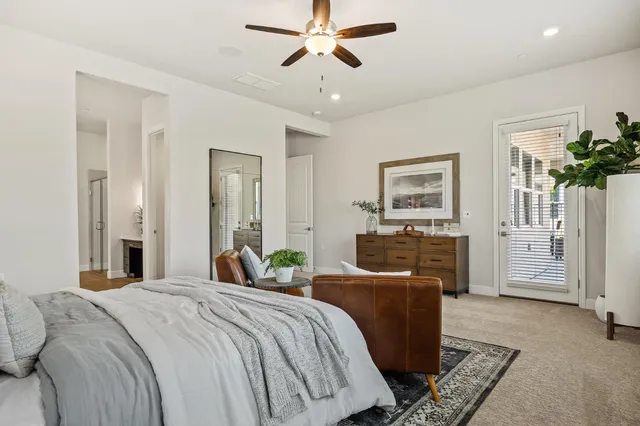 a bedroom with a bed dresser and wooden floor