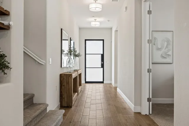 a view of a hallway to rooms and stairs