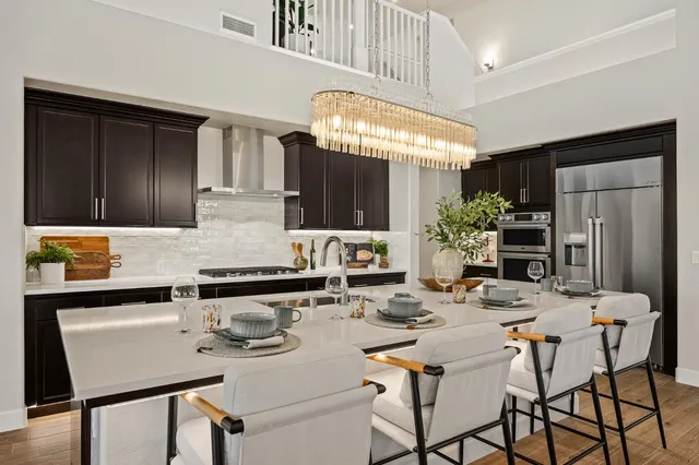a kitchen with stainless steel appliances kitchen island granite countertop a dining table and chairs