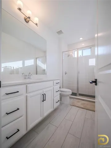 a spacious bathroom with a double vanity sink toilet and shower