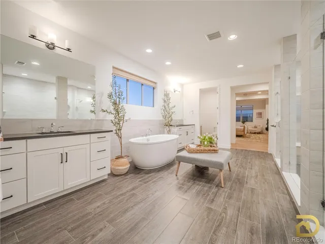 a large room with kitchen island a sink wooden floor and glass doors