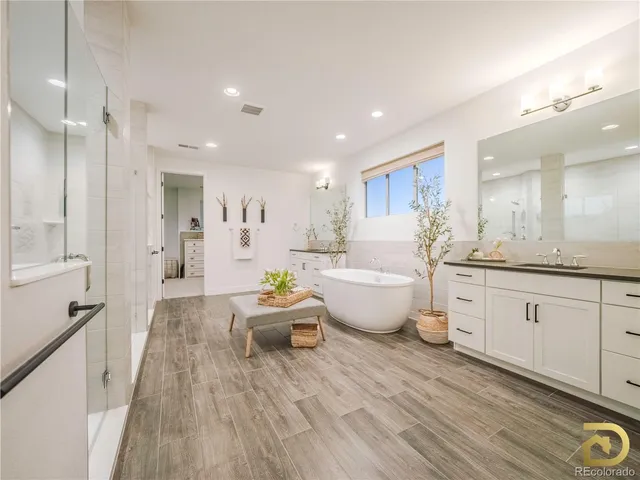 a large white kitchen with wooden floors and white walls
