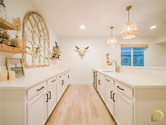 a large white kitchen with a large island oven a sink a stove and a dining table