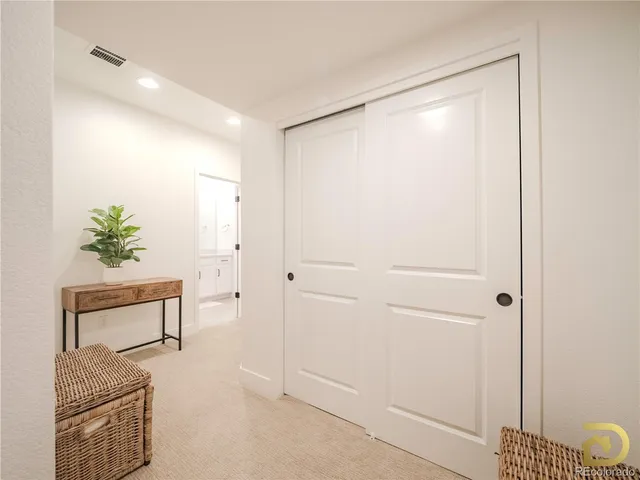 a hallway with painting and a potted plant