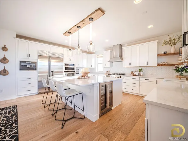 a kitchen with stainless steel appliances kitchen island granite countertop a sink cabinets and wooden floor