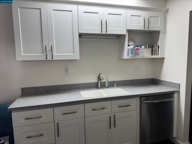 a kitchen with white cabinets and a sink