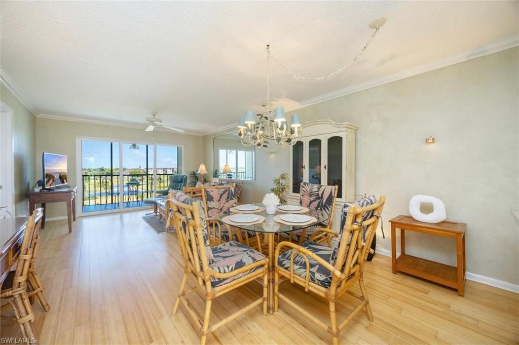21 High Point Circle East, Unit 502 Naples, FL 34103 - Photo 11 of 24 a view of a dining room with furniture and wooden floor