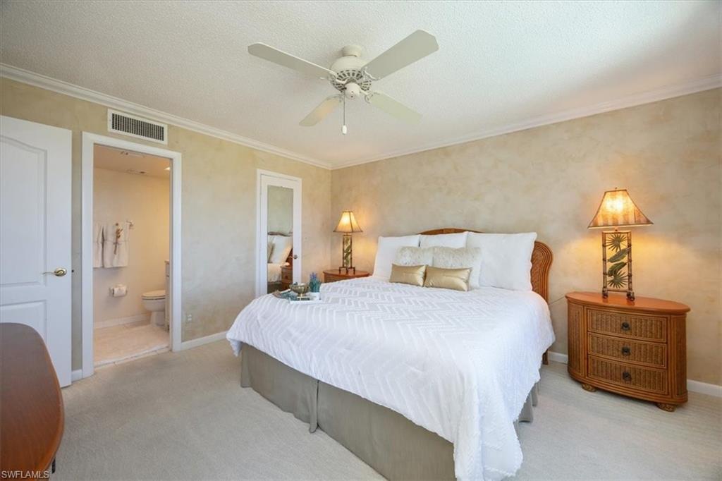 21 High Point Circle East, Unit 502 Naples, FL 34103 - Photo 13 of 24 a bedroom with a bed and a chandelier