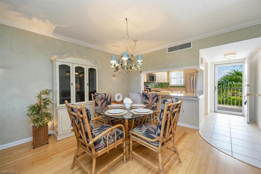 21 High Point Circle East, Unit 502 Naples, FL 34103 - Photo 22 of 24 a view of a dining room with furniture window and wooden floor