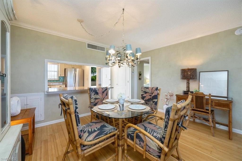21 High Point Circle East, Unit 502 Naples, FL 34103 - Photo 5 of 24 a view of a dining room with furniture and wooden floor
