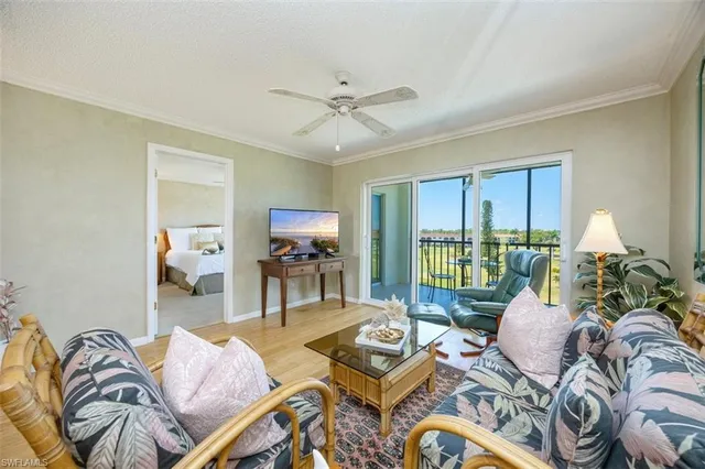 a living room with furniture a flat screen tv and floor to ceiling window