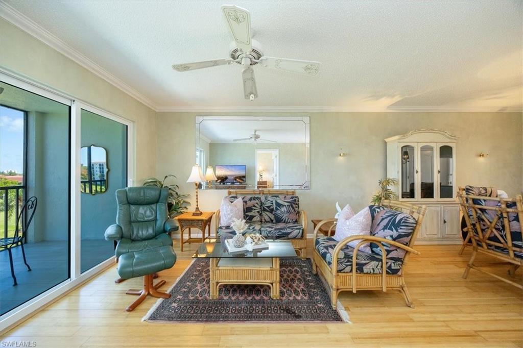 21 High Point Circle East, Unit 502 Naples, FL 34103 - Photo 8 of 24 a living room with furniture and a chandelier