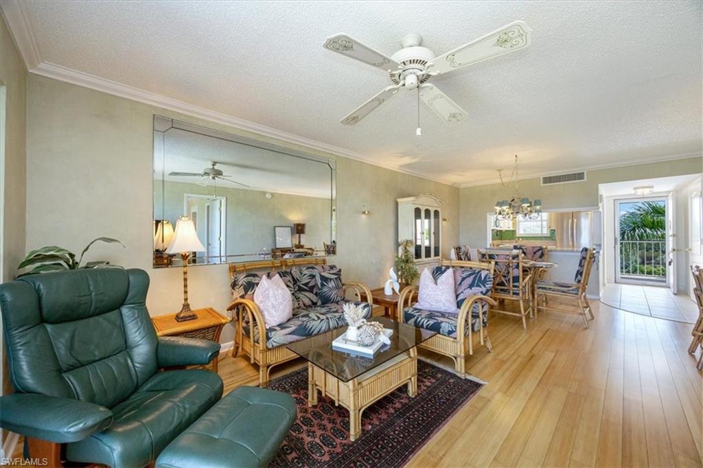 21 High Point Circle East, Unit 502 Naples, FL 34103 - Photo 9 of 24 a living room with furniture and wooden floor