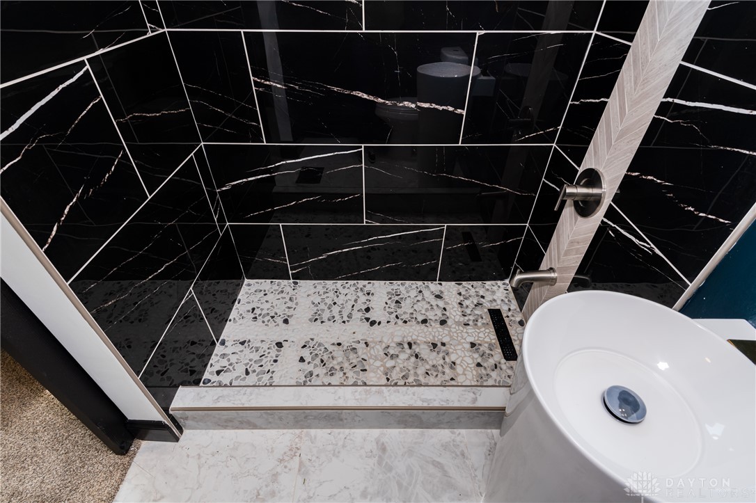 5240 Haverfield Road Dayton, OH 45432 - Photo 35 of 58 This modern bathroom features striking tile work and a sleek vessel sink.
