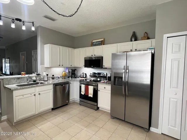 a kitchen with stainless steel appliances granite countertop a refrigerator sink and stove